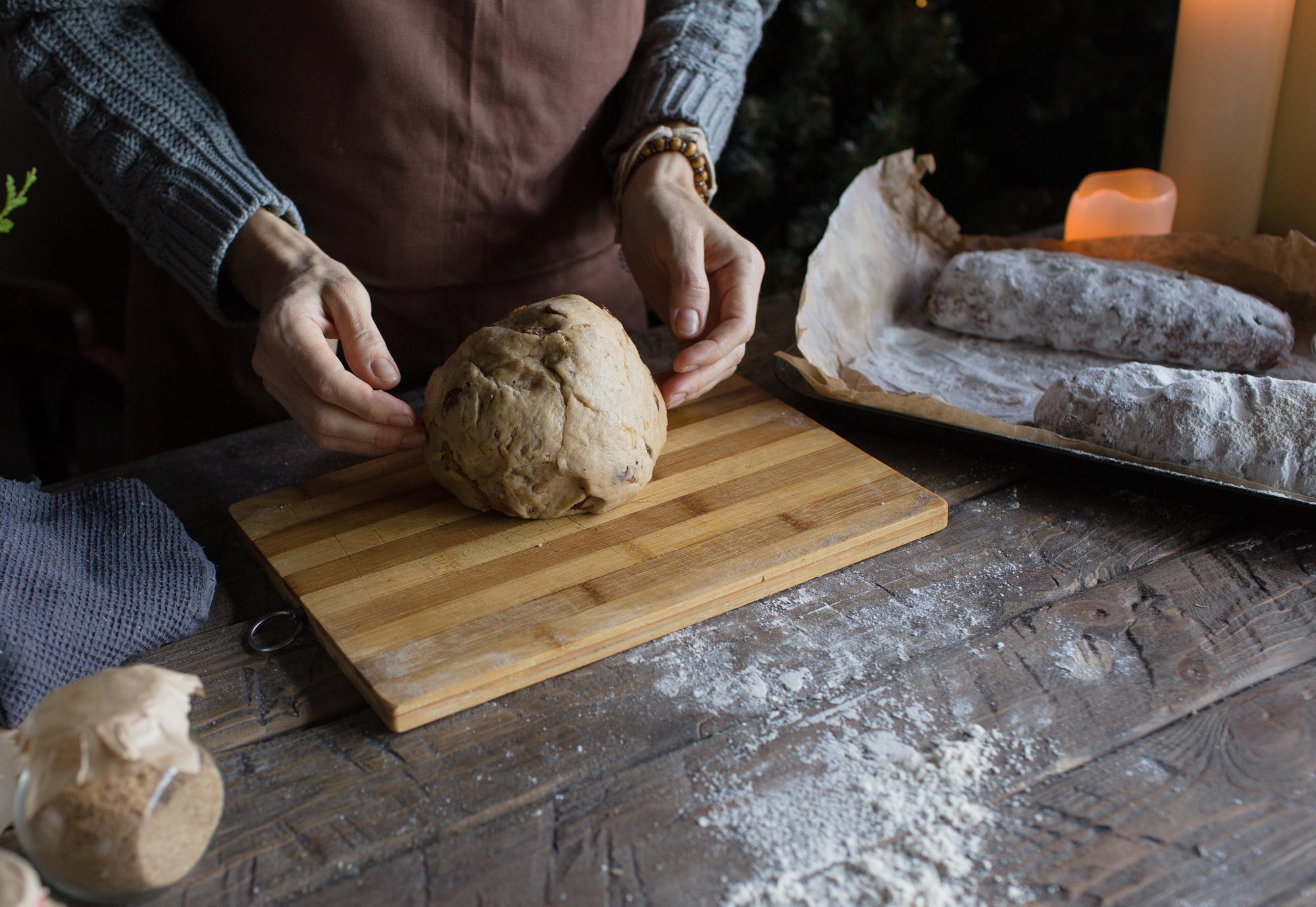 Close-up of hands preparing dough on a wooden table
